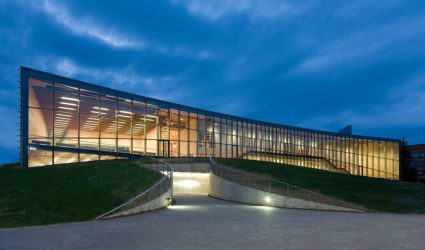 modern-university-buildings-glass-facade-lit-up-at-night-on-a-curved-ground-surface.jpg